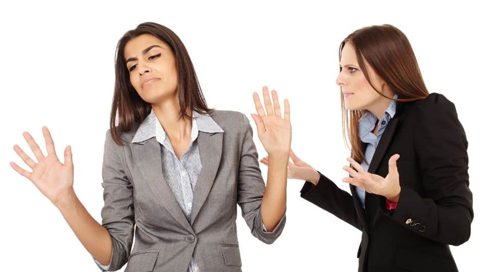 Two women employees having difficult awkward conversation during work.