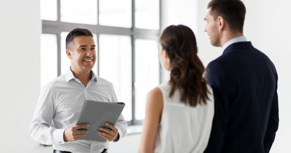 A man business representative talking to a couple about their business