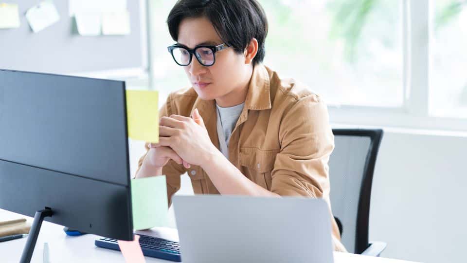 Business owner increasing his focus while working in the office in front of a laptop while doing 90 day planning