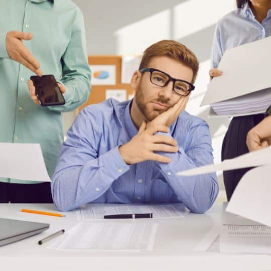 Frustrated man employee being handled with workloads and cellphone work