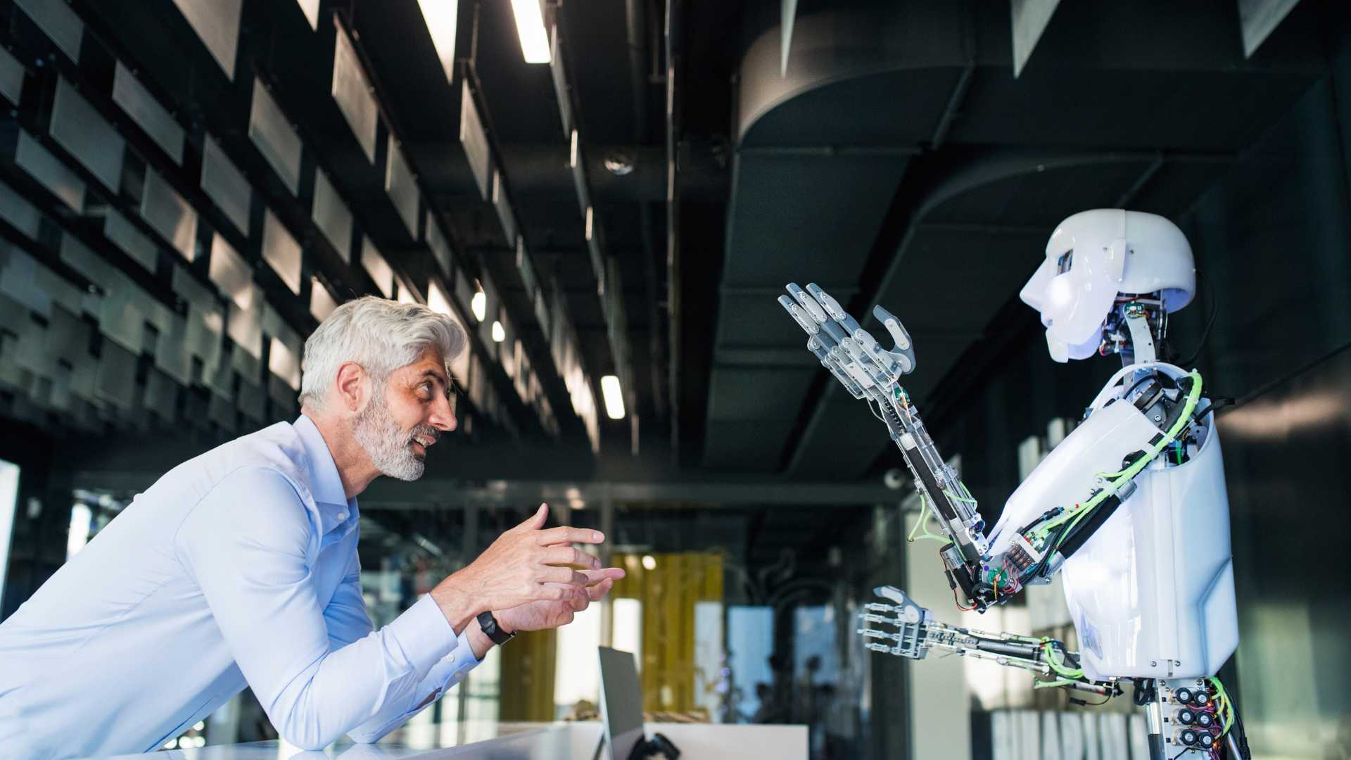 Artificial Intelligene (1) Business man talking to a robot with Artificial Intelligence inside an office