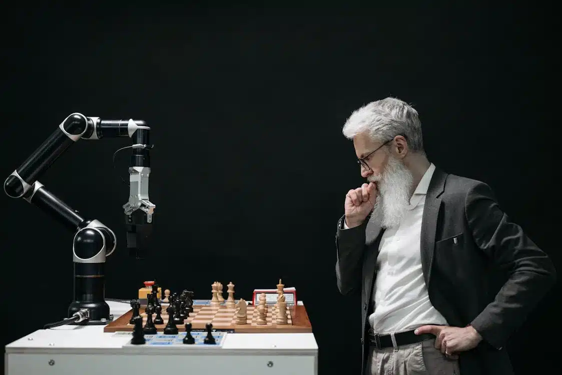 pexels-photo-8438918 Business man looking at the chess in table and playing against a Robot with Artificial Intelligence