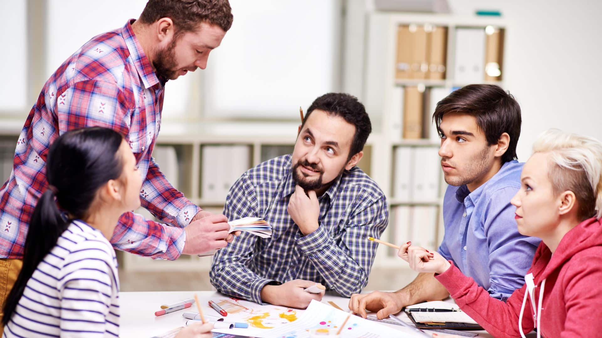 suggestion Team member suggesting an idea to other four team members in an office setting